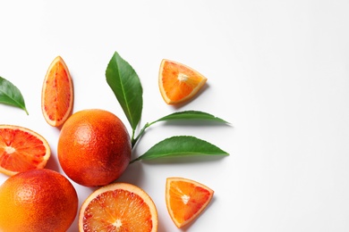 Fresh bloody oranges and leaves on white background, top view. Citrus fruits