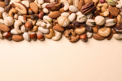 Flat lay composition with organic mixed nuts and space for text on color background