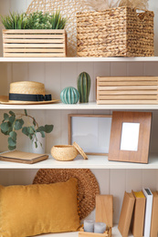 Photo of White shelving unit with plants and different decorative stuff