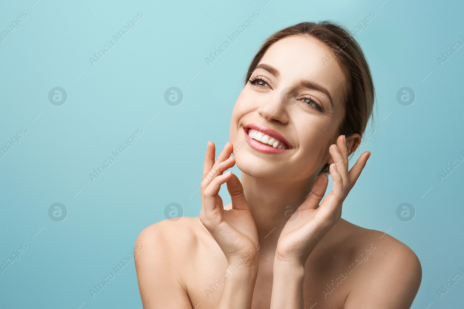 Photo of Beautiful young woman with silky skin on color background