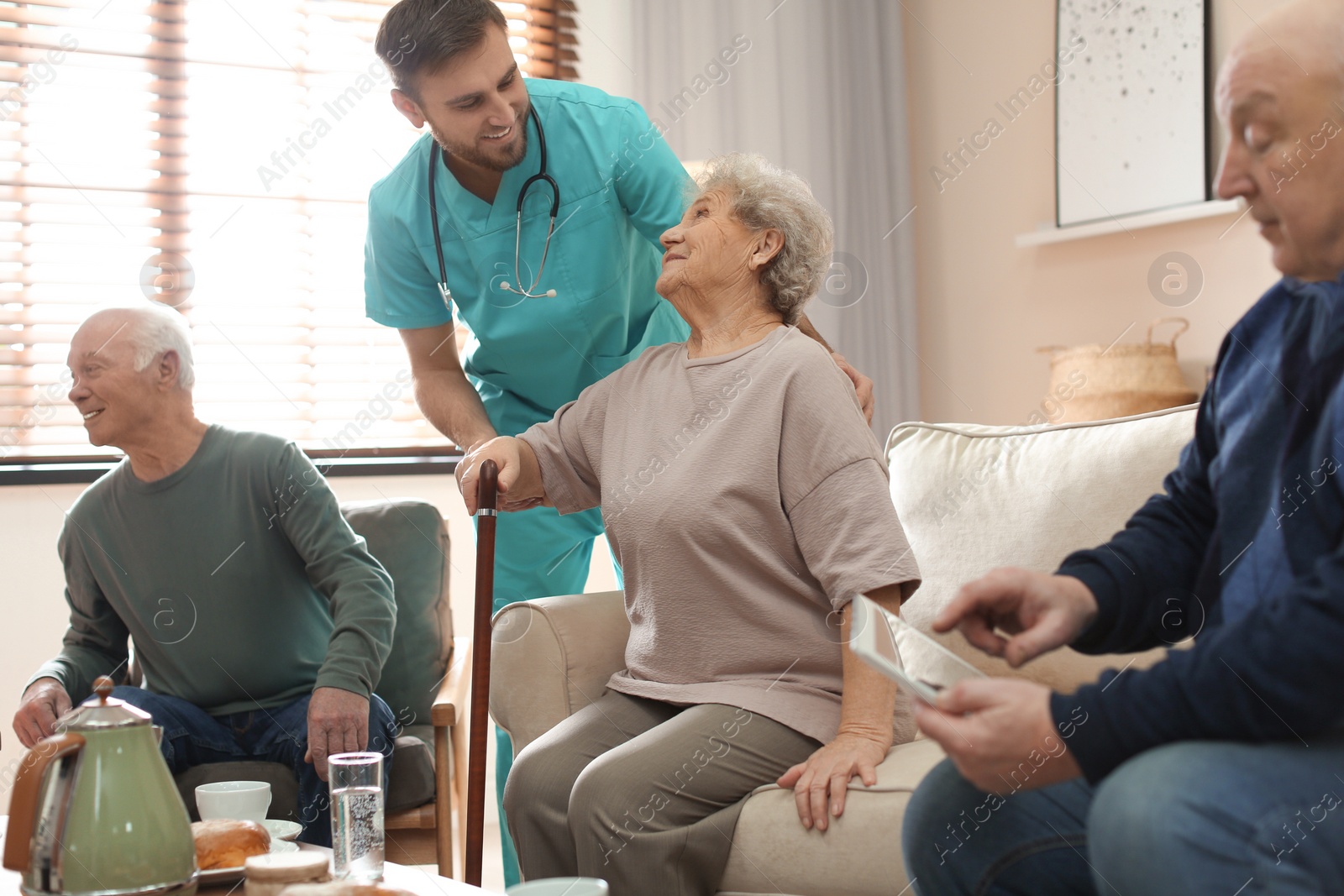 Photo of Medical worker taking care of elderly woman in geriatric hospice