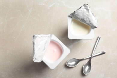 Photo of Plastic cups with different yogurts on light background