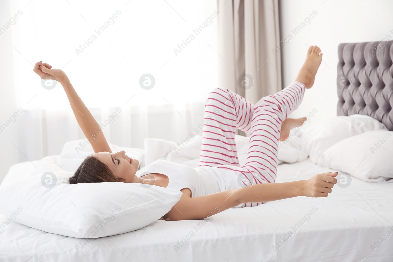 Photo of Beautiful teen girl lying with comfortable pillow in bed at home