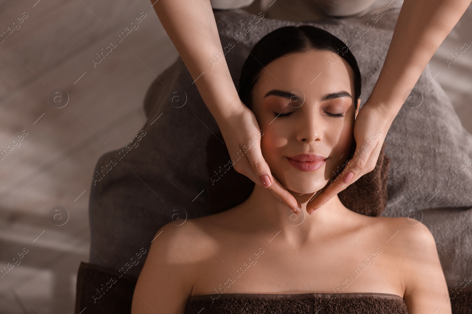 Photo of Spa therapy. Beautiful young woman lying on table during massage in salon, top view. Space for text