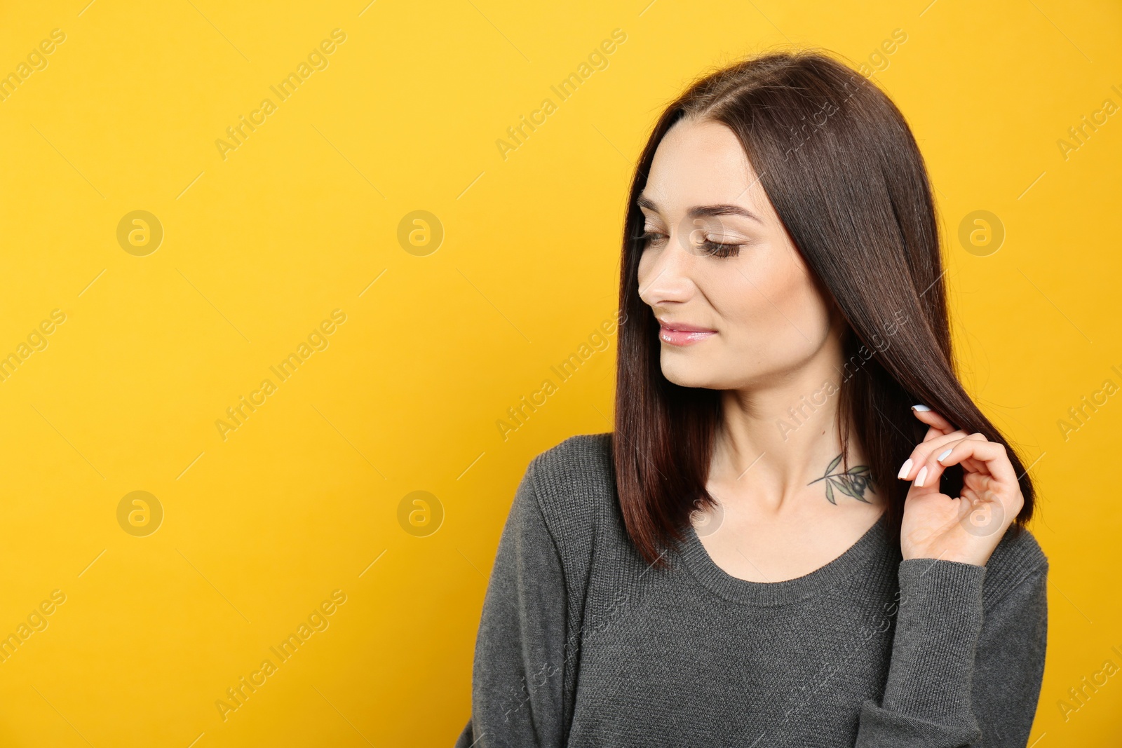 Photo of Portrait of pretty young woman with gorgeous chestnut hair on yellow background, space for text