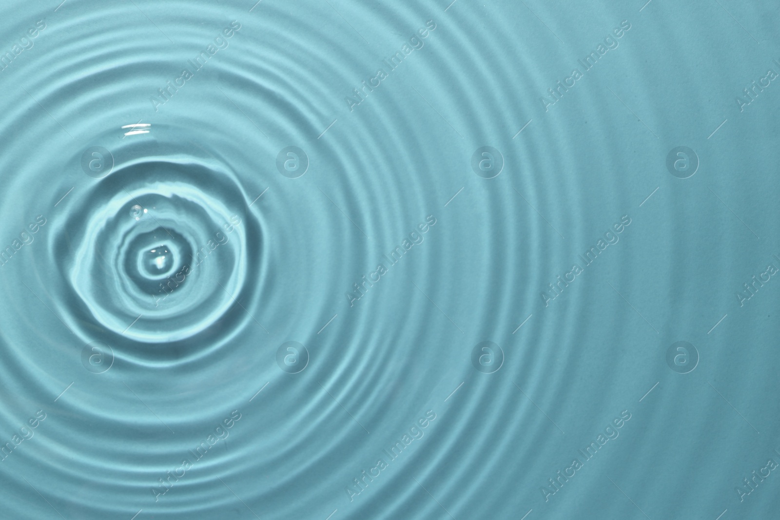 Image of Rippled surface of clear water on light blue background, top view