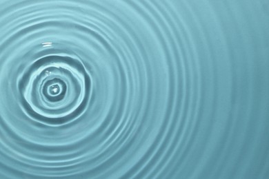 Rippled surface of clear water on light blue background, top view