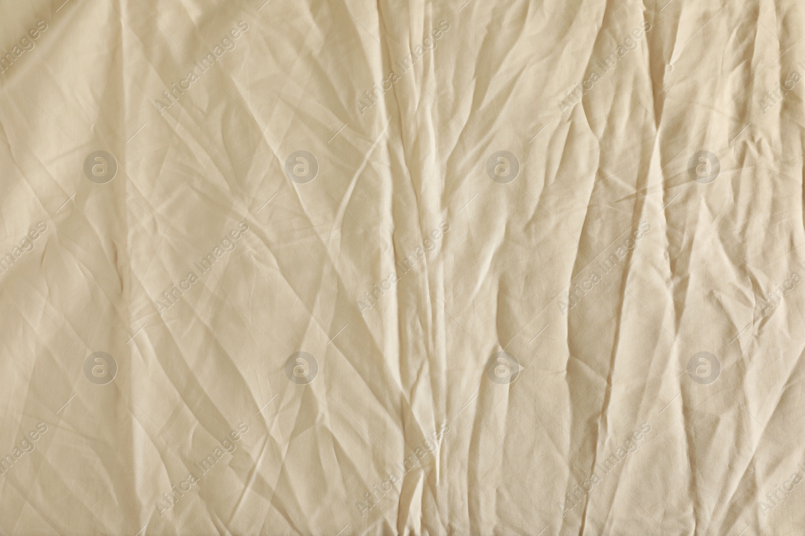 Photo of Crumpled beige fabric as background, top view