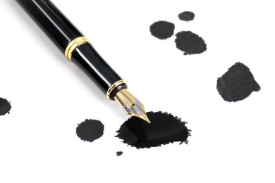 Photo of Stylish black fountain pen and blots of ink isolated on white