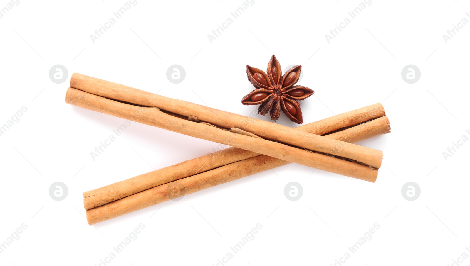 Photo of Aromatic cinnamon sticks and anise isolated on white, top view