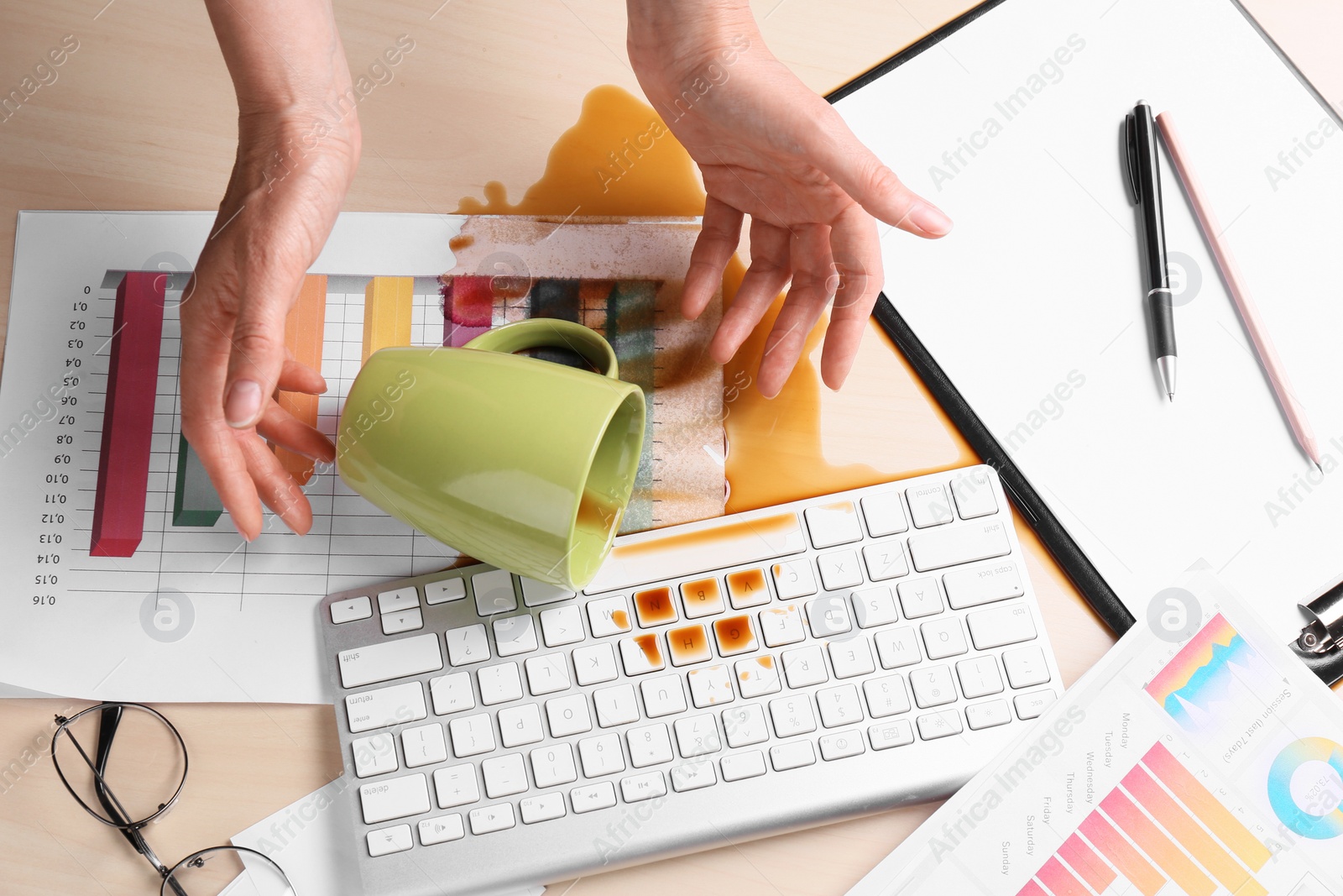 Photo of Woman with coffee spilled over her workplace, above view