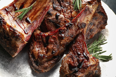 Delicious grilled ribs with rosemary in plate, closeup