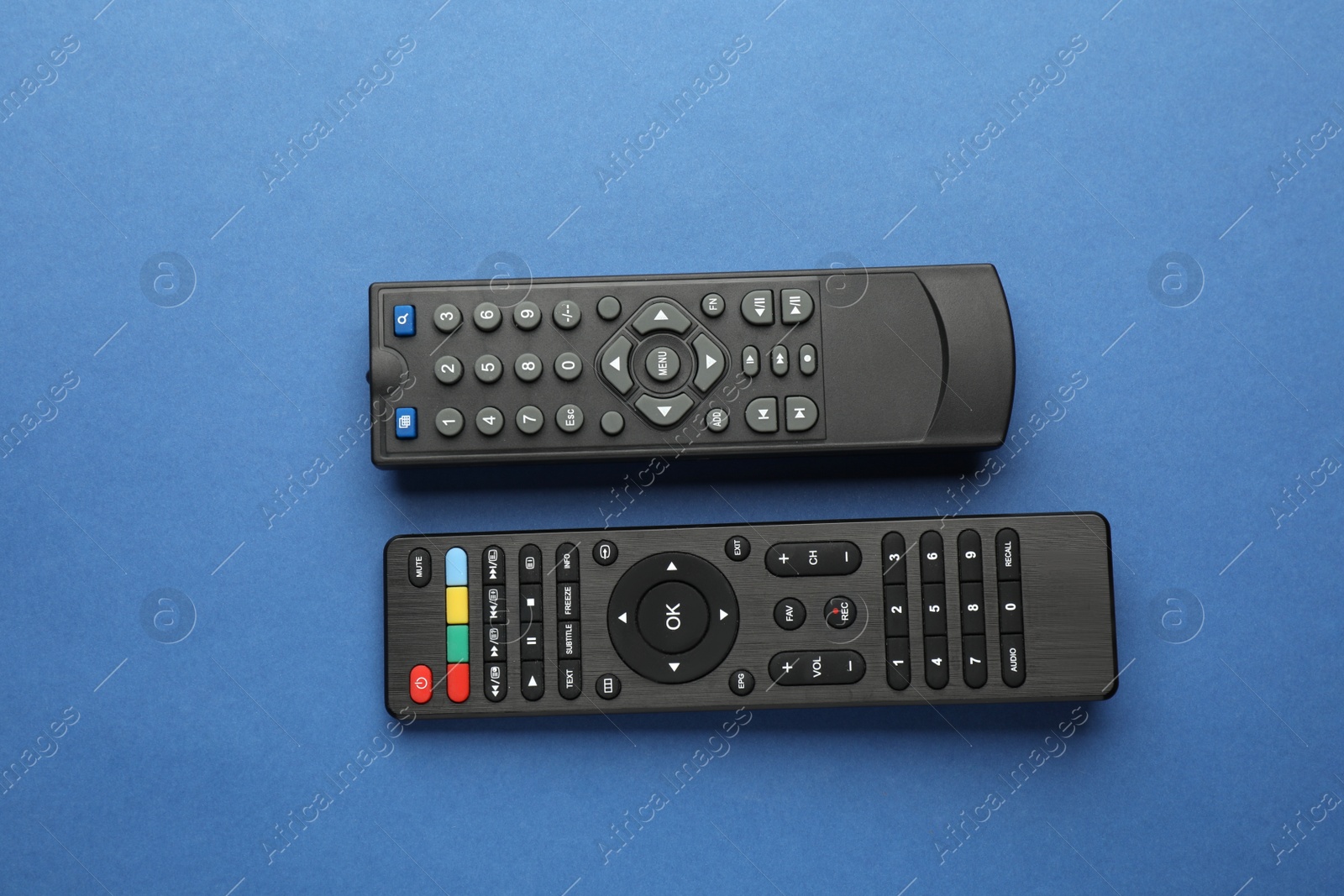 Photo of Different remote controls on blue background, flat lay