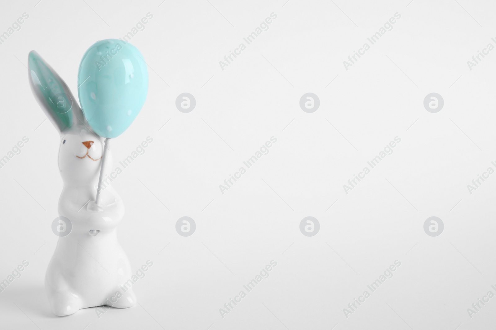 Photo of Easter bunny figure on white background. Space for text