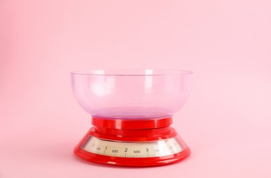 Photo of Kitchen scale with plastic bowl on pink background