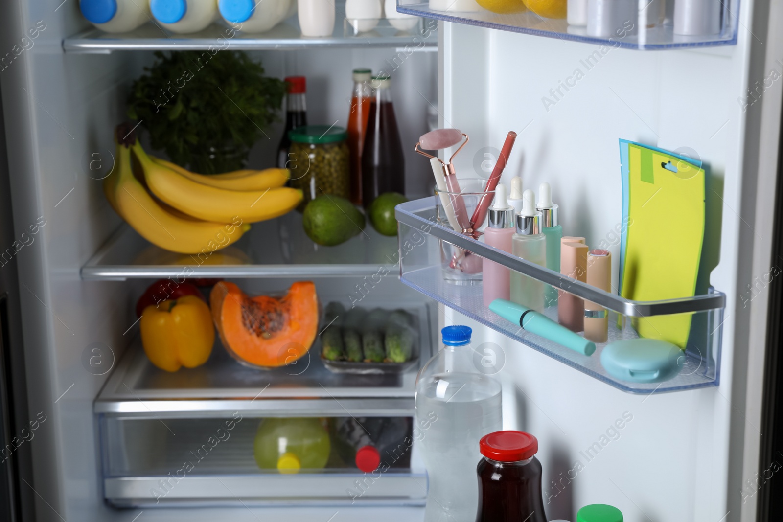 Photo of Storage of cosmetics and tools in refrigerator door bin next to groceries