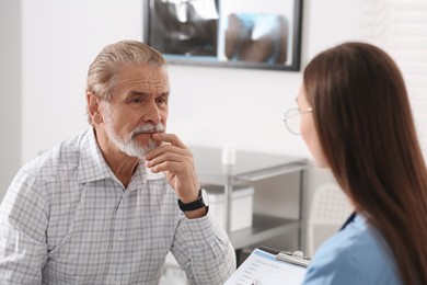 Photo of Professional female orthopedist consulting patient in clinic