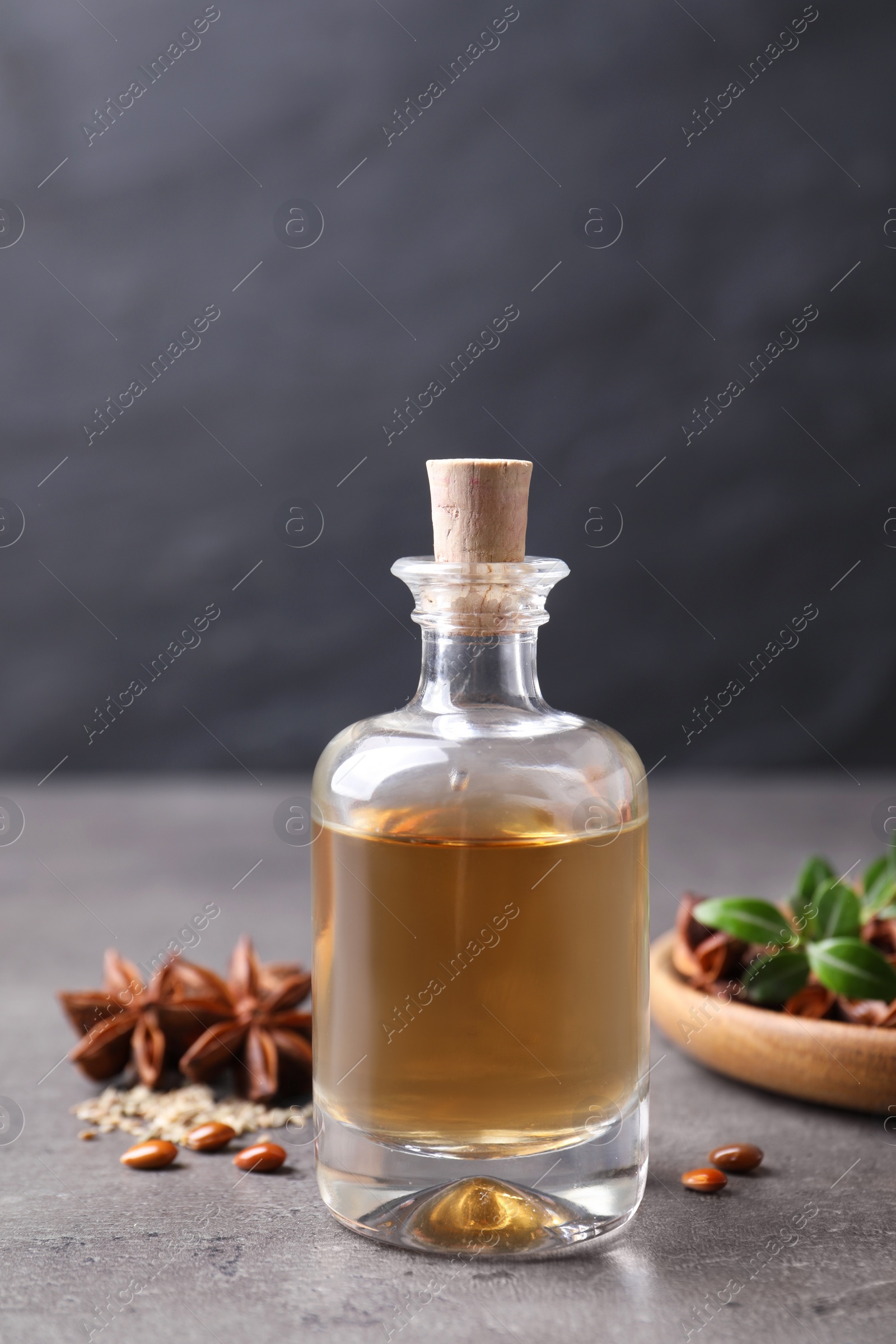 Photo of Anise essential oil and spices on grey table