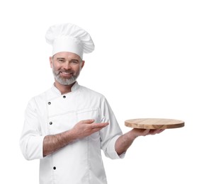 Photo of Happy chef in uniform pointing at wooden board on white background