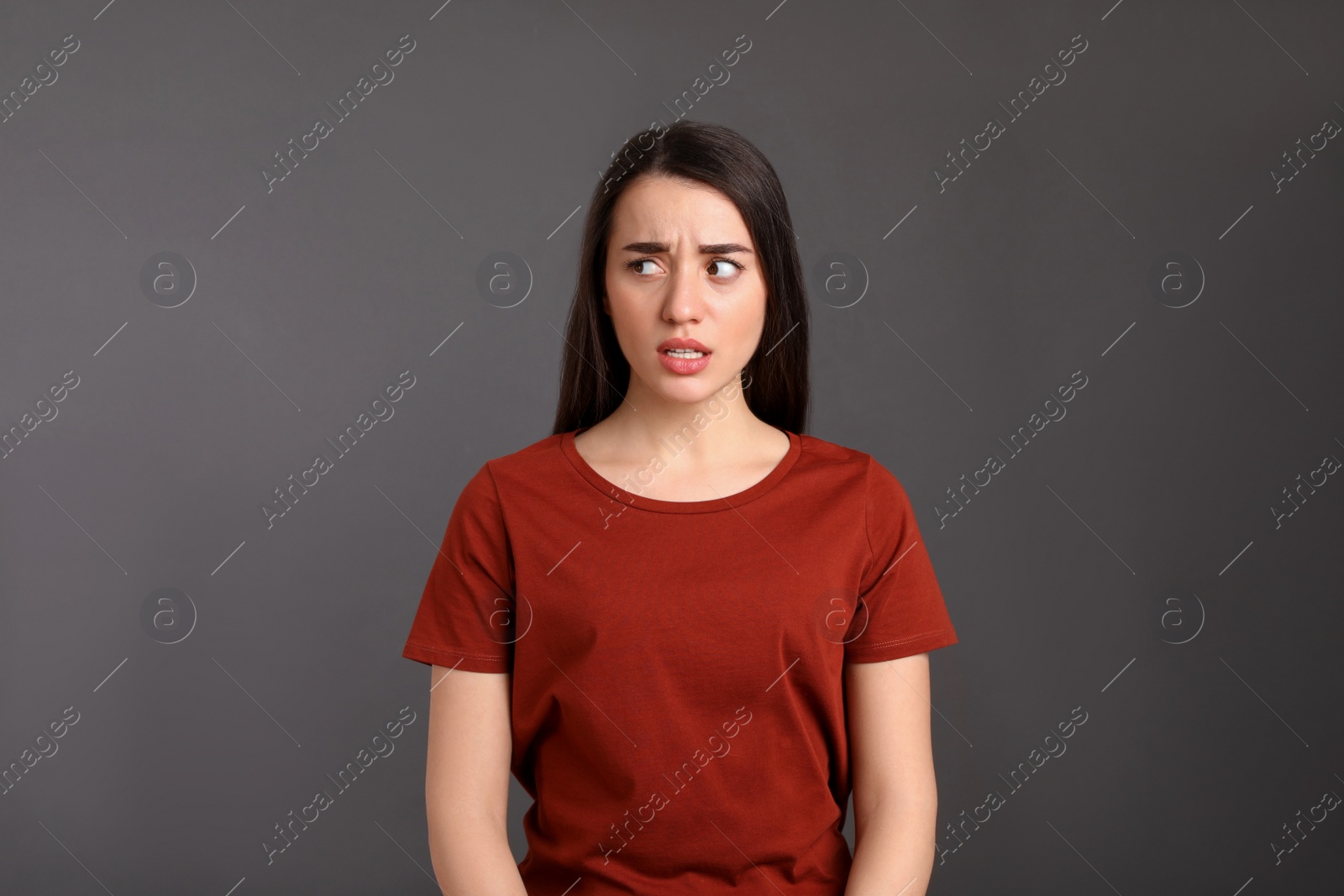 Photo of Portrait of emotional young woman on dark grey background. Personality concept