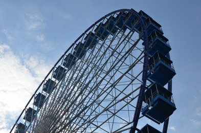 Amusement park. Beautiful Ferris wheel against blue sky, low angle view