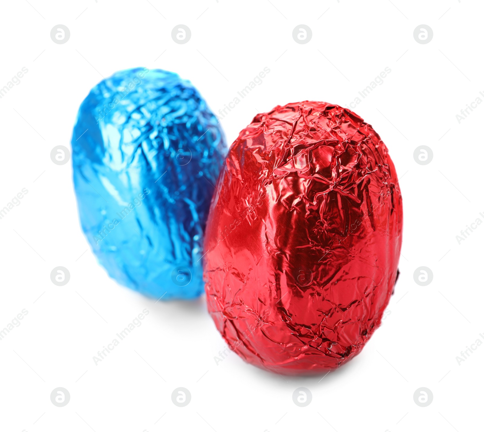 Photo of Chocolate eggs wrapped in bright foil on white background