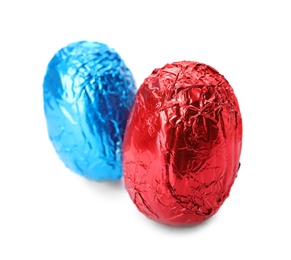 Chocolate eggs wrapped in bright foil on white background