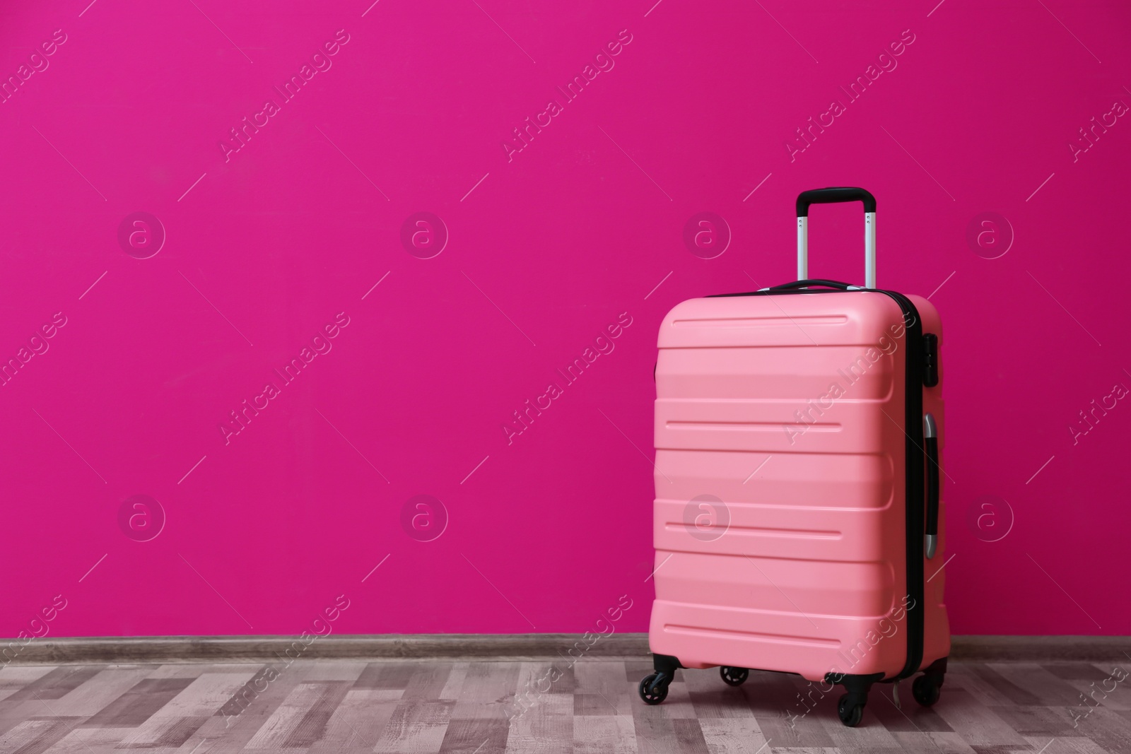 Photo of Packed suitcase near color wall with space for text