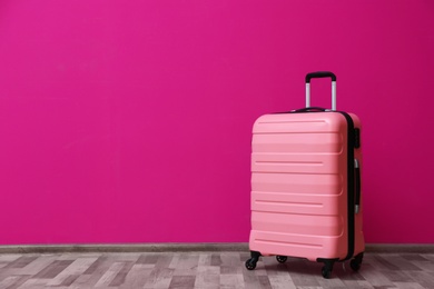 Packed suitcase near color wall with space for text