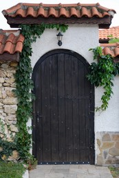 Photo of Entrance of building with beautiful arched wooden door outdoors