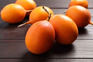 Photo of Delicious ripe granadillas on wooden table, closeup