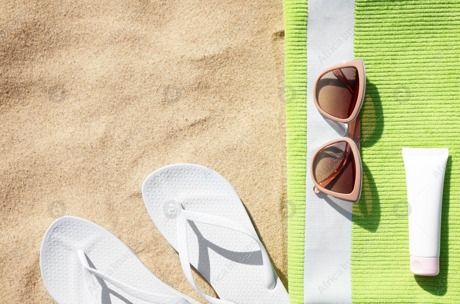 Photo of Flat lay composition with different beach accessories on sand. Space for text