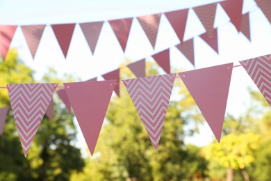 Photo of Pink bunting flags in park. Party decor