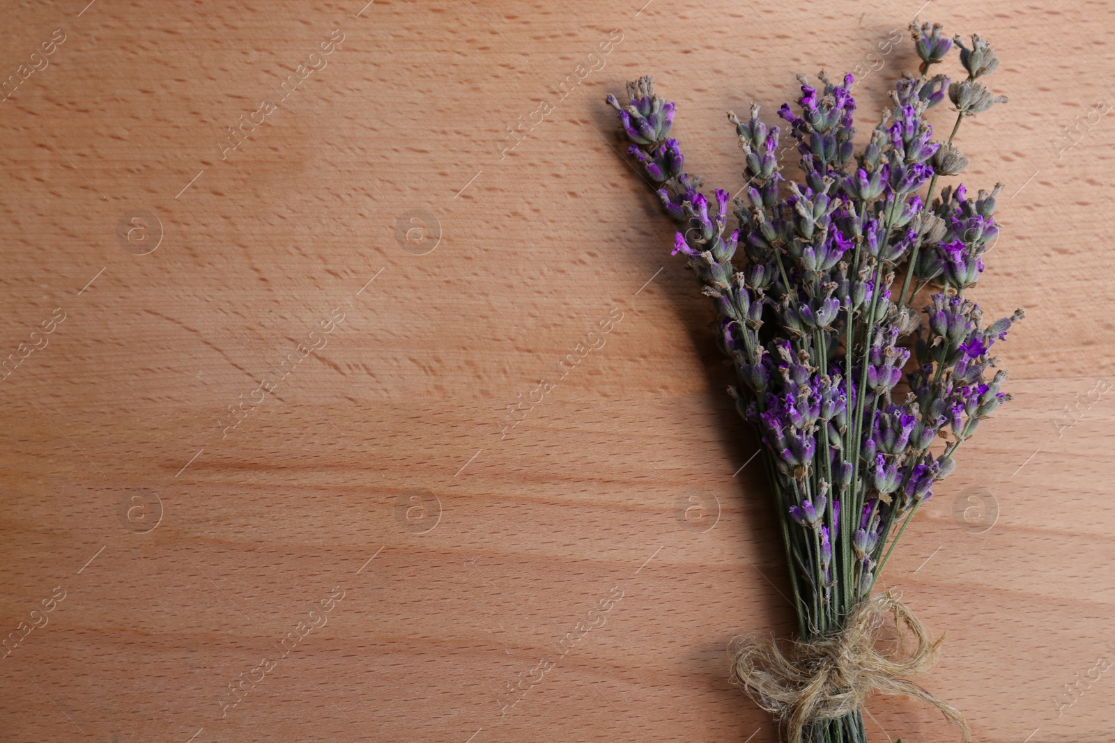 Photo of Bouquet of beautiful lavender flowers on wooden table, top view. Space for text