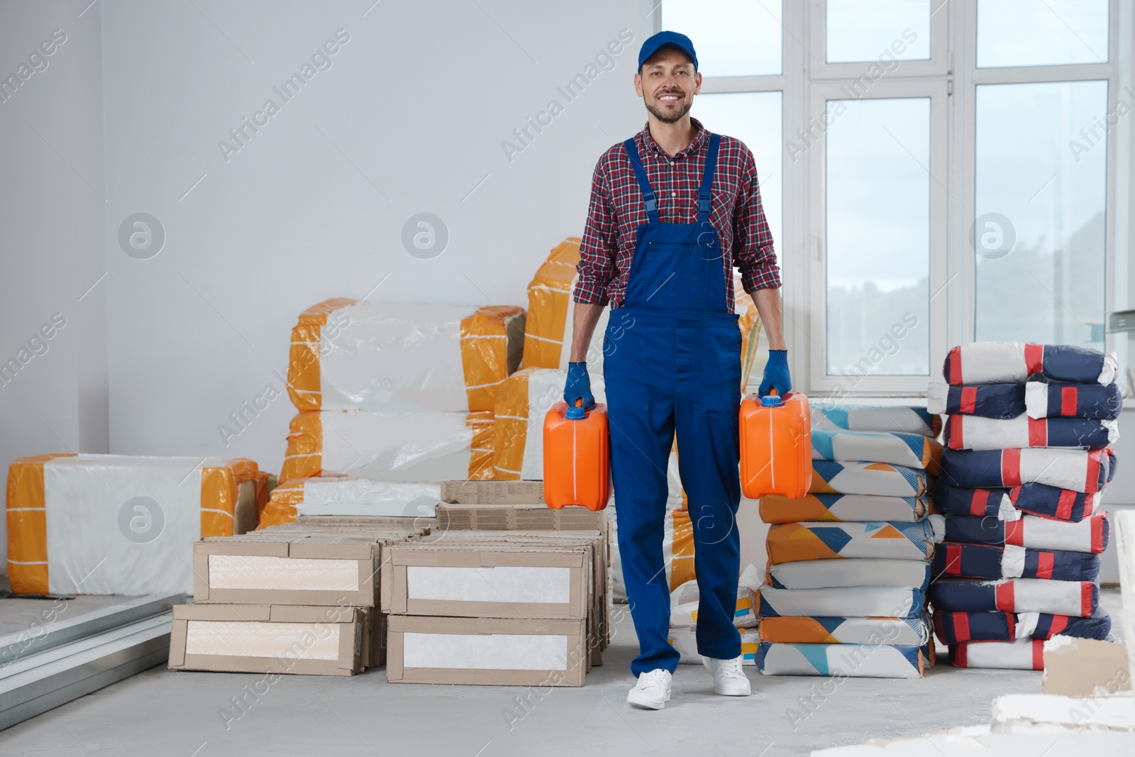 Photo of Construction worker carrying canisters in room prepared for renovation