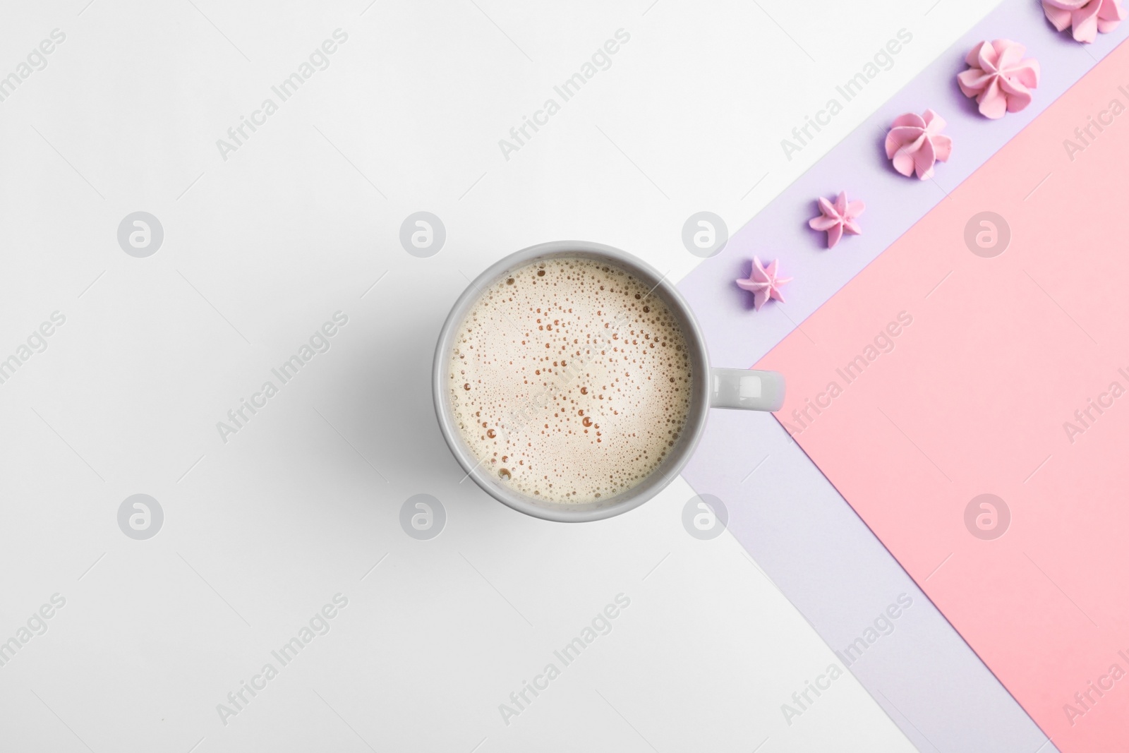 Photo of Cup of coffee and meringues on color background, top view. Space for text