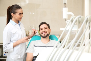 Photo of Professional dentist working with patient in modern clinic