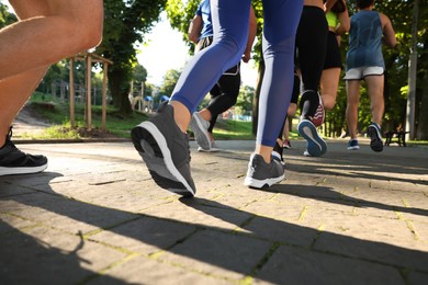 Group of people running in park on sunny day, closeup