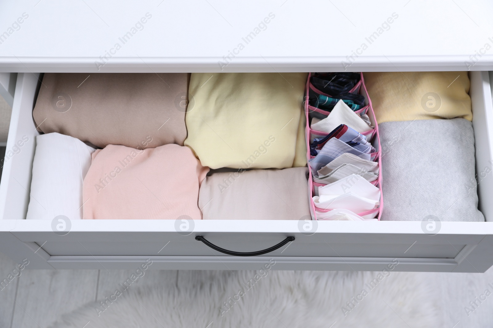 Photo of Open drawer with folded handkerchiefs and clothes indoors, above view