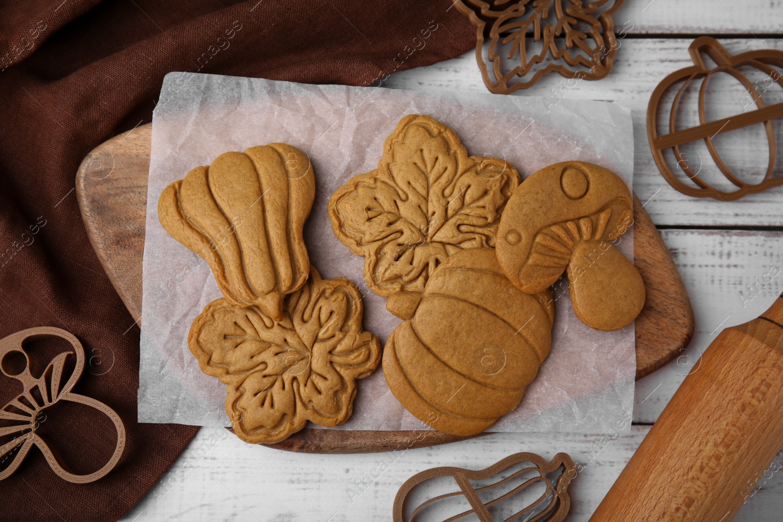 Photo of Tasty cookies and cutters on white wooden table, flat lay