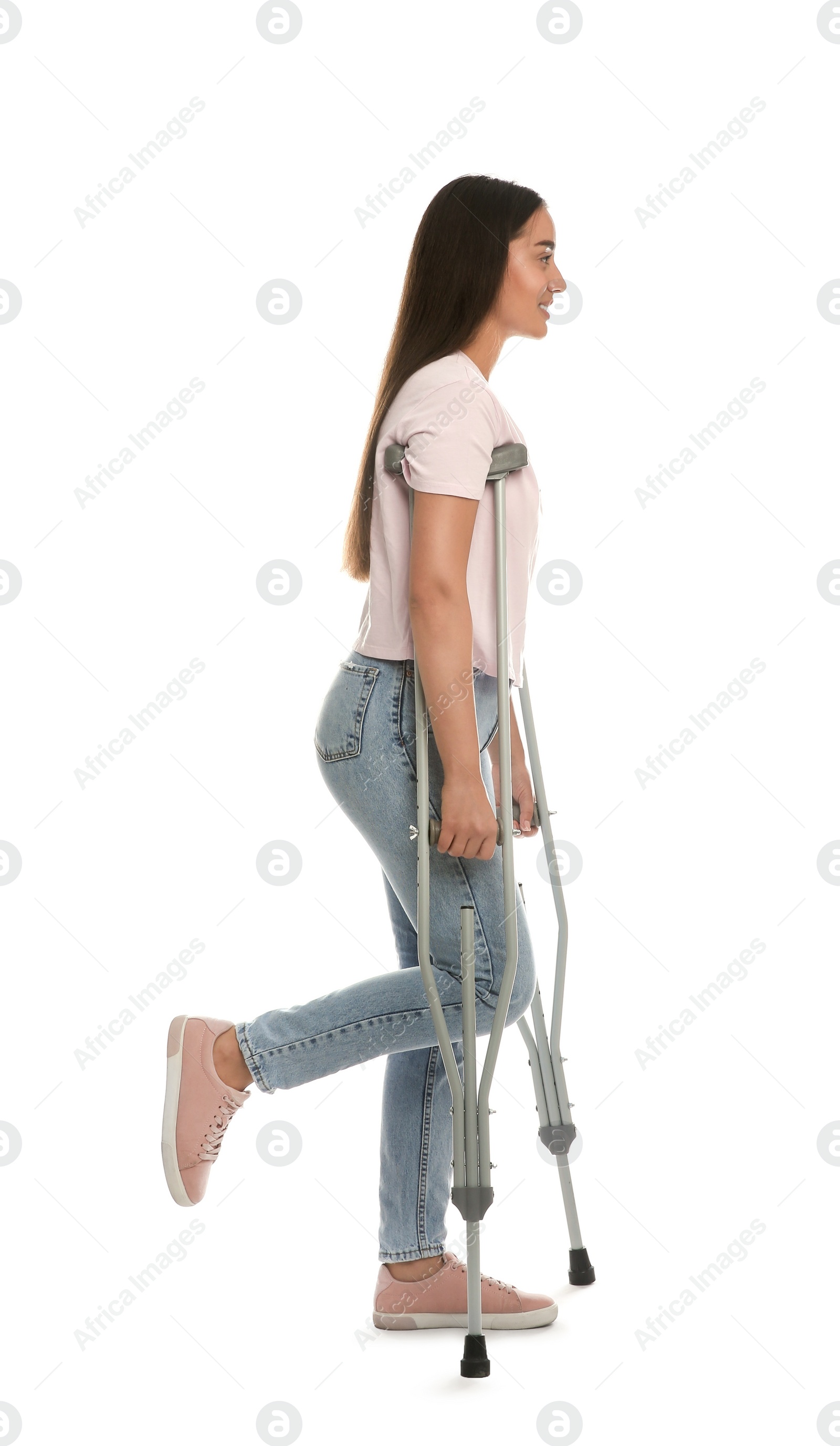 Photo of Young woman with axillary crutches on white background