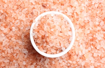 Pink himalayan salt and bowl as background, top view