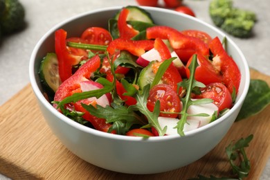 Photo of Tasty fresh vegetarian salad on light grey table, closeup