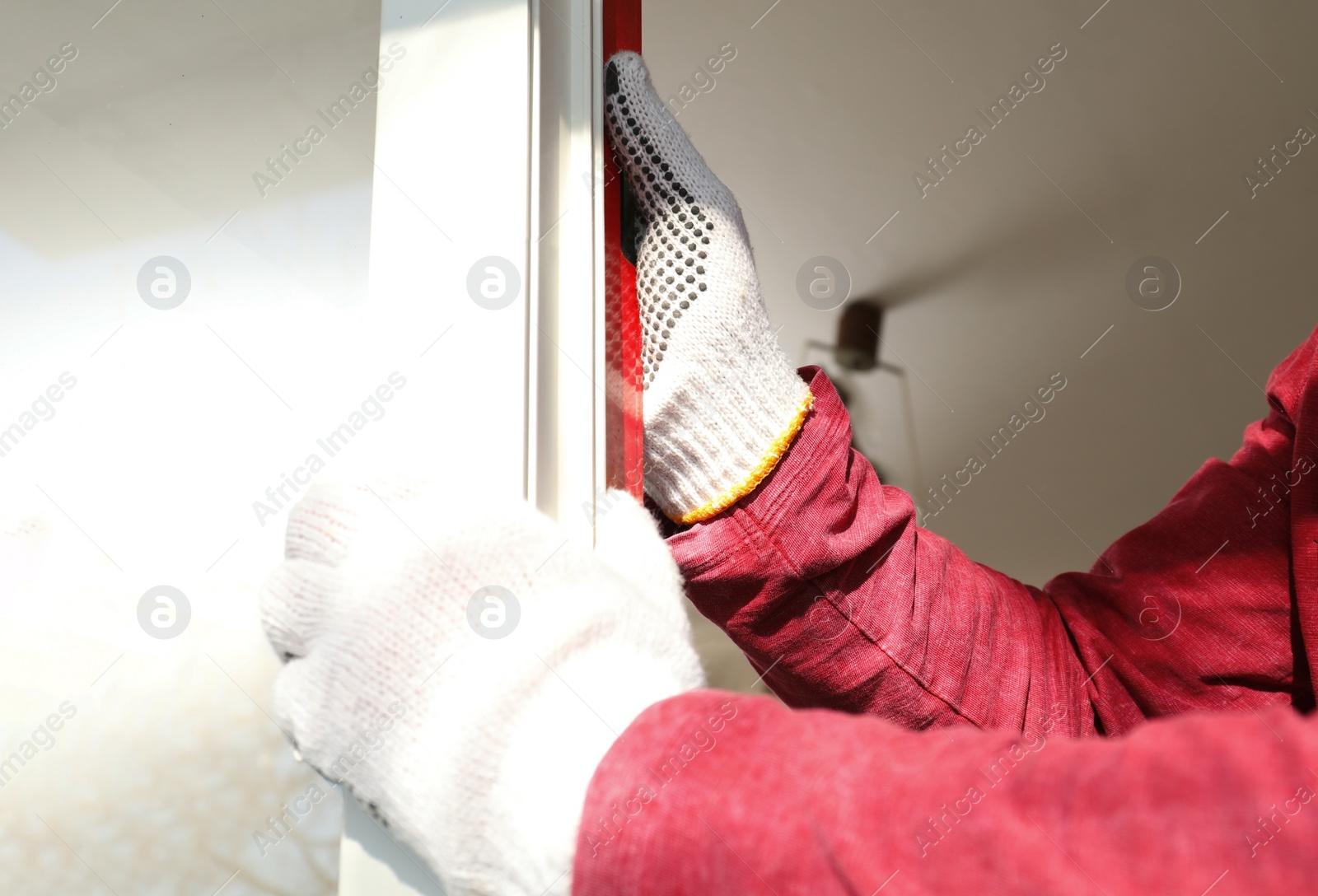 Photo of Workers installing plastic window indoors, closeup view