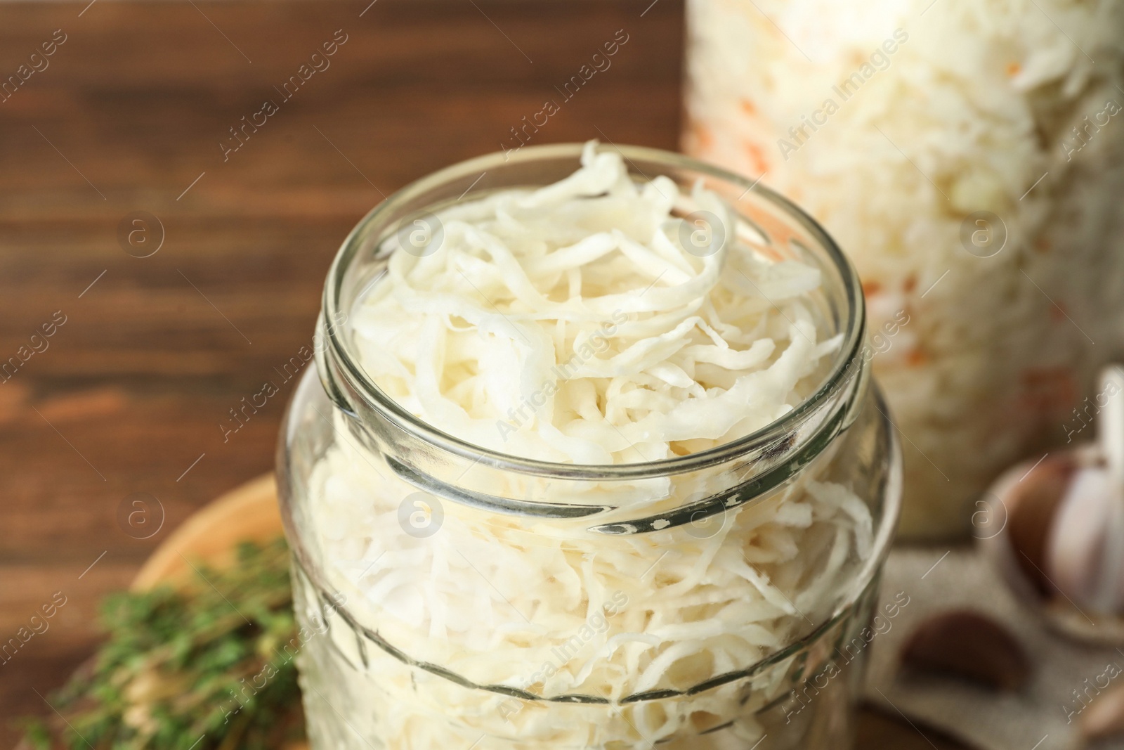 Photo of Jar of tasty fermented cabbage on table, closeup