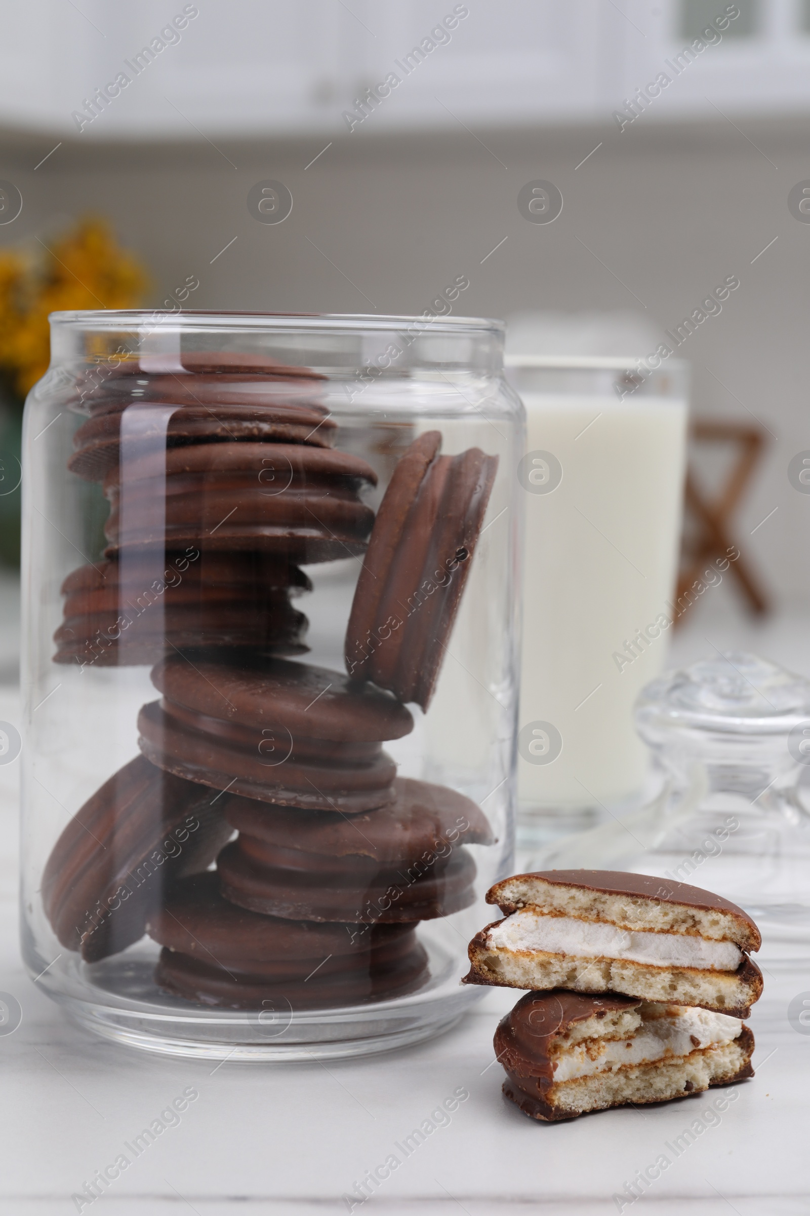 Photo of Jar with delicious choco pies and glass of milk on white table in kitchen