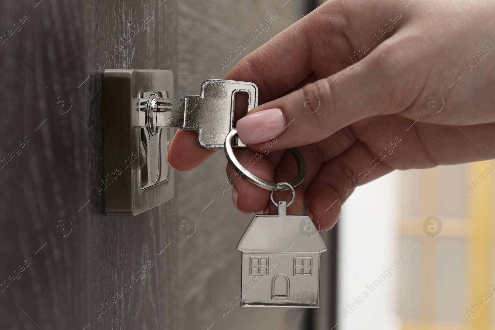 Photo of Woman unlocking door with key, closeup view