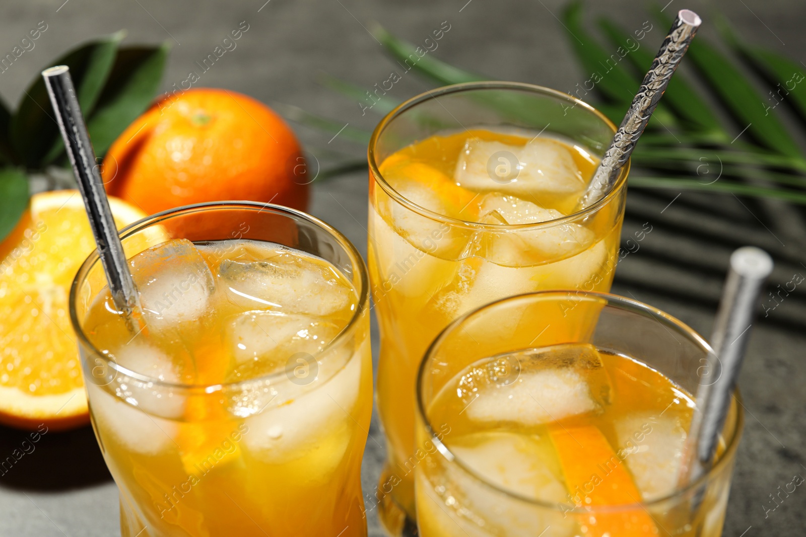 Photo of Delicious orange soda water in glasses, closeup