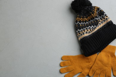 Photo of Stylish gloves and hat on grey background, flat lay. Space for text