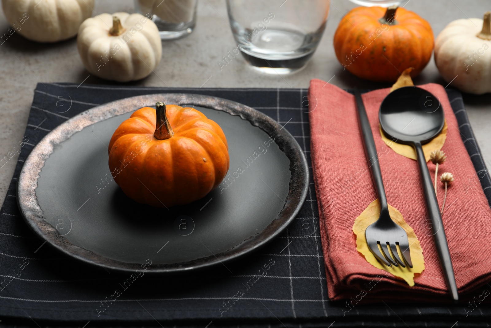 Photo of Seasonal table setting with pumpkins and autumn leaves on grey background